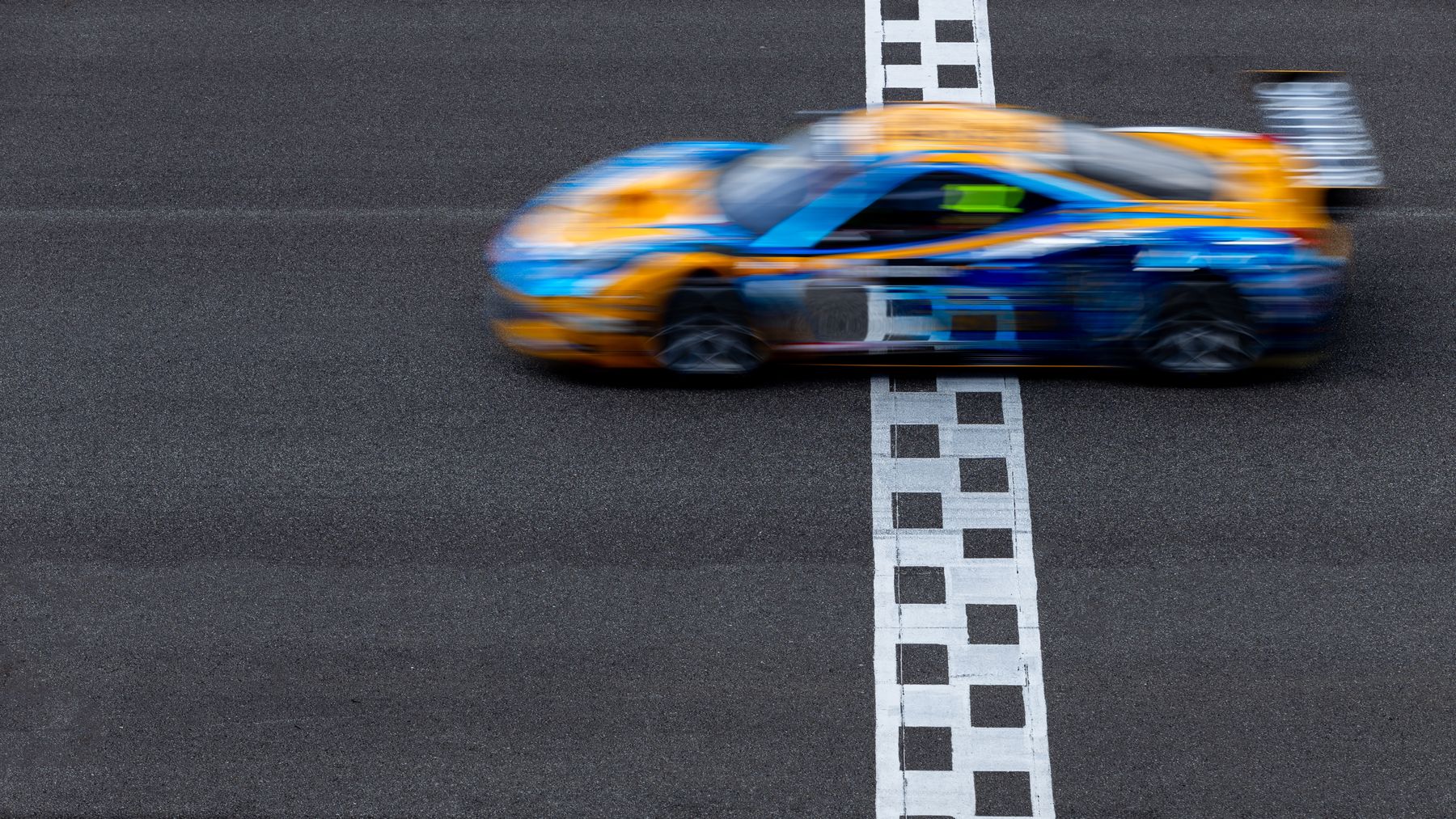 Race car speeding over the finish line
